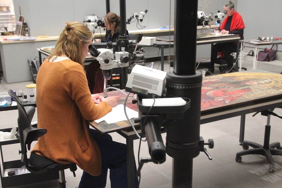 Eine Restauratorin an der Arbeit der „Tronende Godheid“