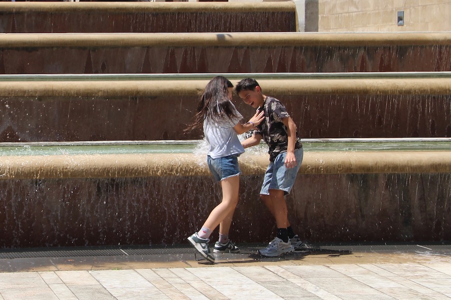 Bei über dreißig Grad im Schatten freuen sich die Kinder über Wasserspaß am Brunnen auf dem Place du Chapitre.